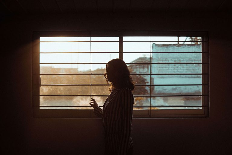 woman standing looking out window