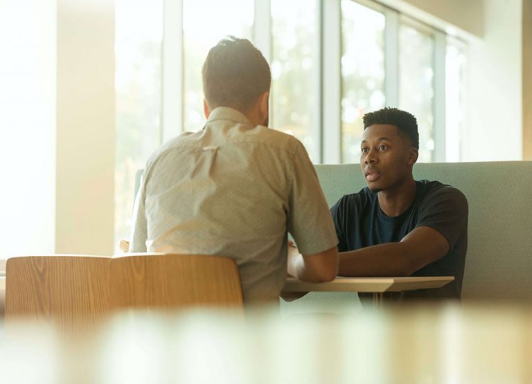 elder man speaking with younger man