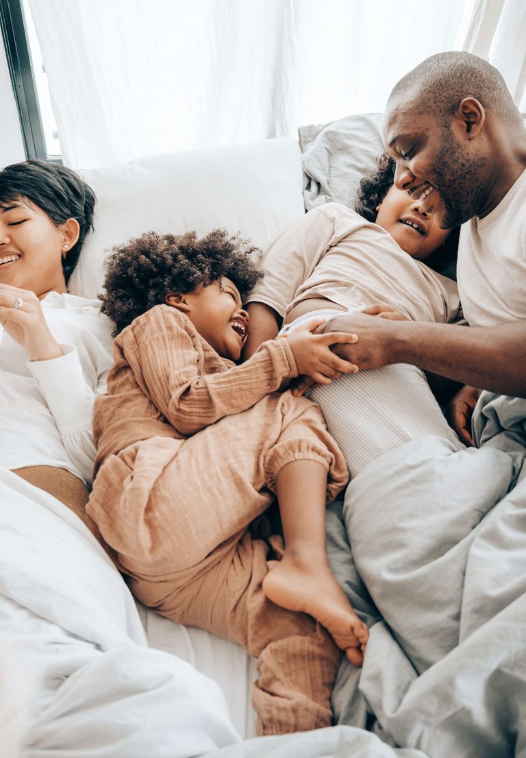 family cuddling in bed