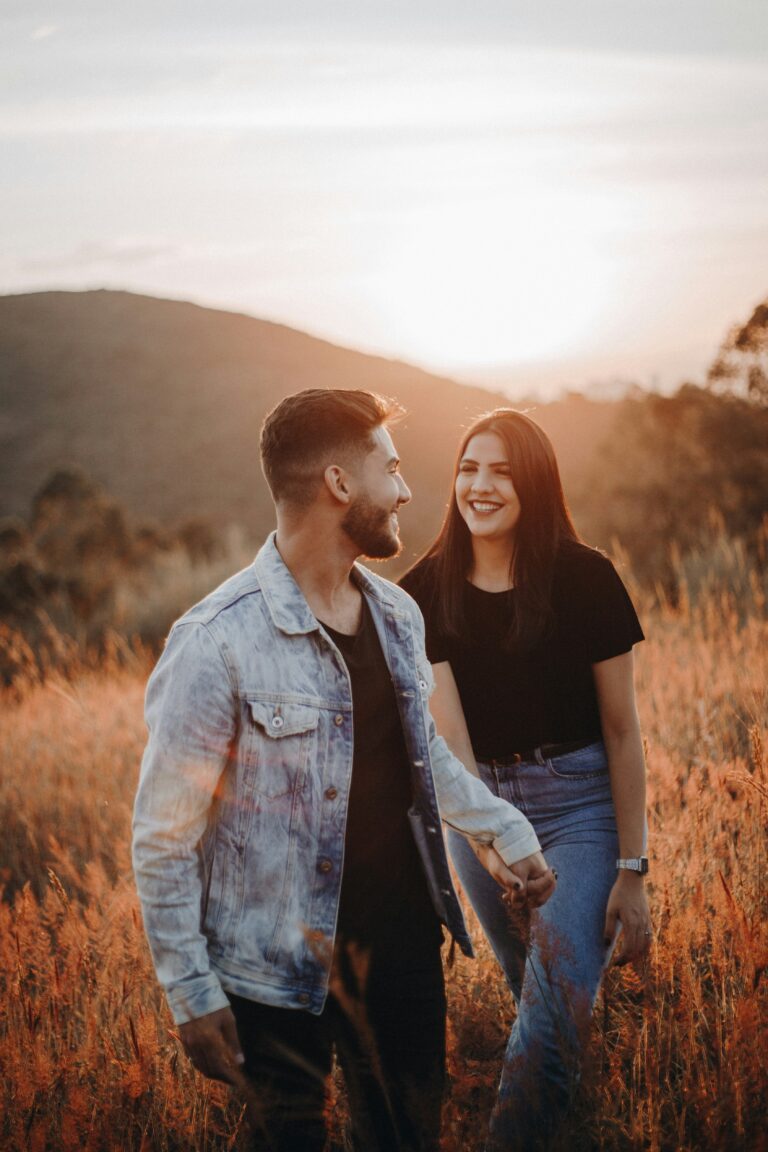 couple holding hands in field